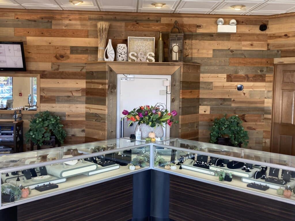 Sam & Sons interior showroom with jewelry display cabinets and wood back wall